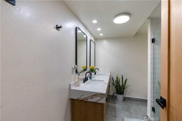 bathroom with double vanity, recessed lighting, a sink, concrete floors, and baseboards