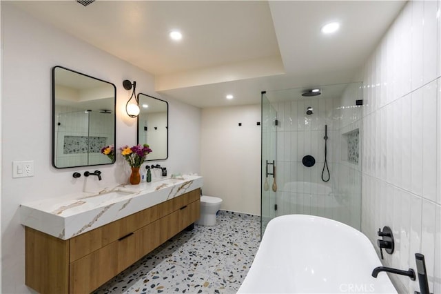 bathroom with toilet, recessed lighting, a sink, double vanity, and a stall shower