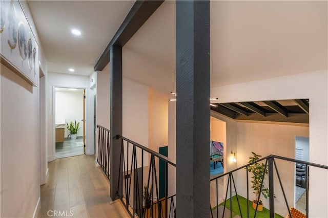 corridor with wood finished floors, an upstairs landing, and recessed lighting