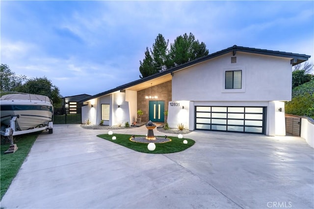 view of front of home featuring a garage, concrete driveway, and stucco siding