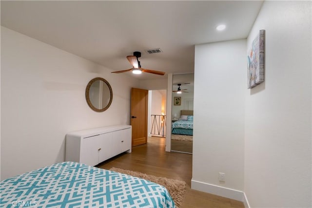 bedroom with visible vents, baseboards, and wood finished floors