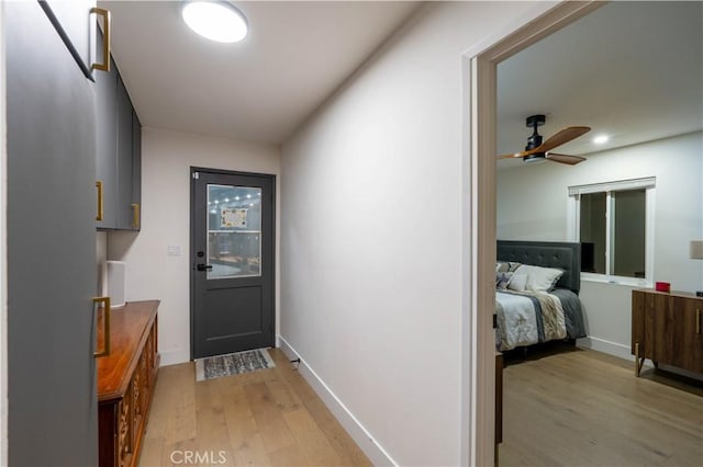 doorway featuring light wood finished floors, ceiling fan, baseboards, and recessed lighting