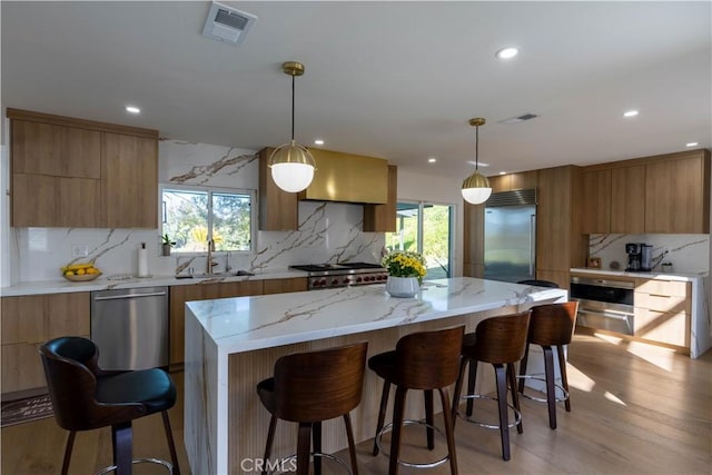 kitchen featuring appliances with stainless steel finishes, modern cabinets, a sink, and visible vents