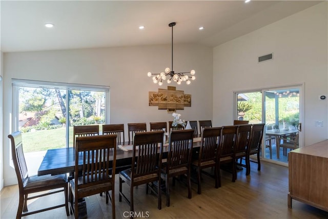 dining space with lofted ceiling, light wood-type flooring, visible vents, and recessed lighting