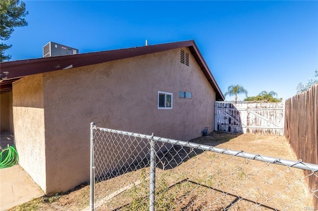 view of side of property with fence and stucco siding