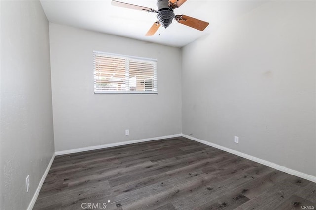 spare room featuring ceiling fan, dark wood finished floors, and baseboards