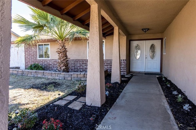 entrance to property with brick siding and stucco siding