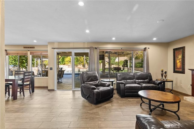 living area with light wood-style flooring, baseboards, and recessed lighting