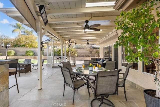 view of patio featuring a ceiling fan, outdoor dining area, a fenced backyard, and an outdoor hangout area