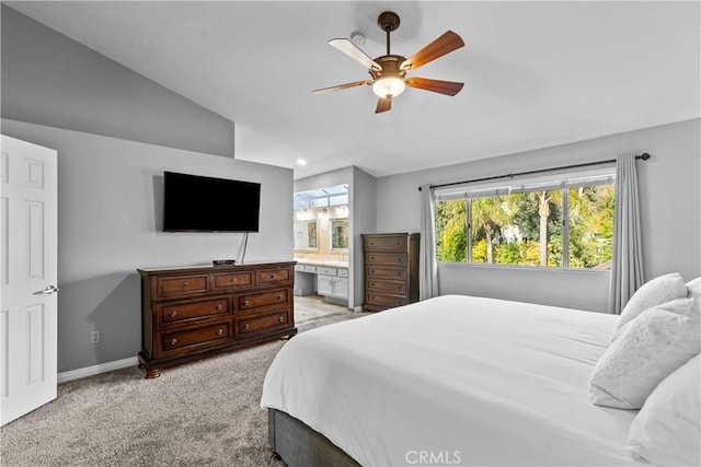 bedroom with light colored carpet, connected bathroom, vaulted ceiling, ceiling fan, and baseboards