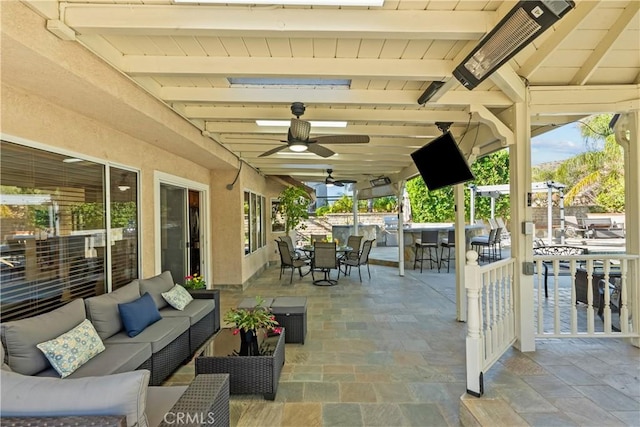 view of patio / terrace featuring an outdoor hangout area, ceiling fan, a bar, and outdoor dining space