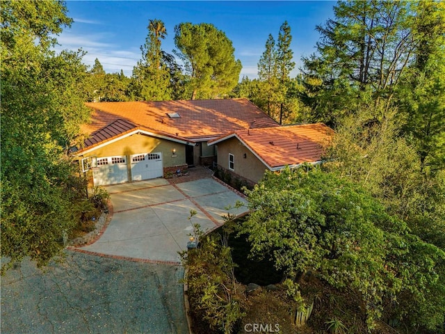 5386 Harter Ln, La Canada Flintridge, CA 91011 - view of front facade with driveway, stucco siding, a tiled roof, and an attached garage