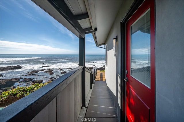 balcony with a water view and a beach view