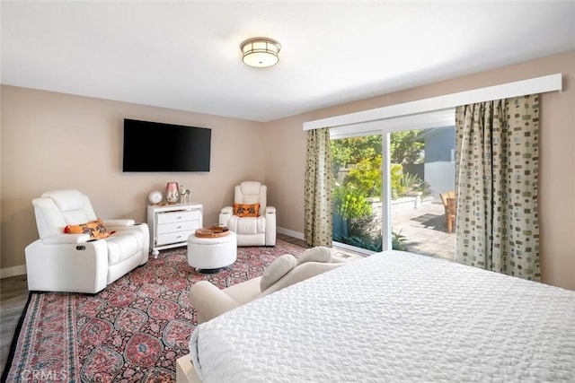 bedroom with access to outside and baseboards