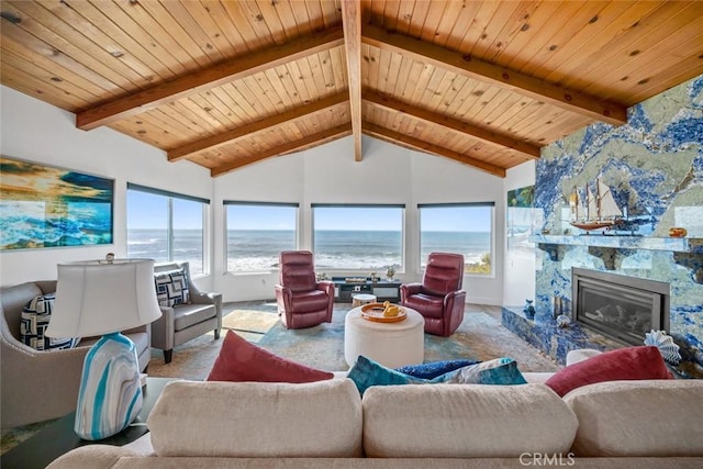 living room featuring carpet floors, a large fireplace, a water view, and beamed ceiling