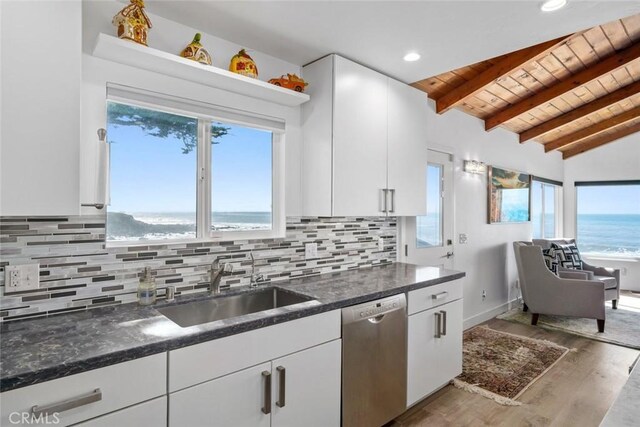 kitchen featuring a water view, a sink, white cabinetry, and stainless steel dishwasher