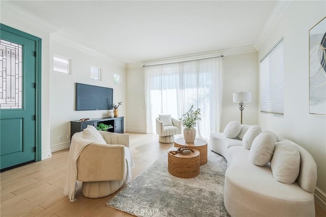 living area with light wood-style flooring, baseboards, and crown molding