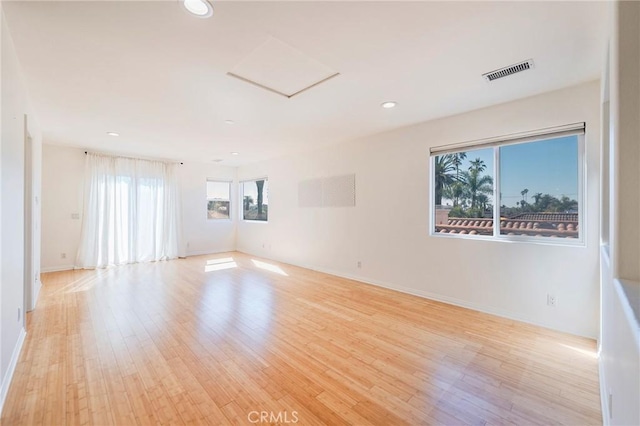 unfurnished room with light wood-style flooring, recessed lighting, visible vents, baseboards, and attic access