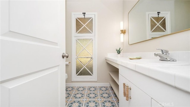 bathroom with tile patterned flooring, vanity, and baseboards