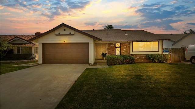 ranch-style house with driveway, brick siding, a front lawn, and an attached garage