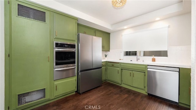 kitchen featuring visible vents, light countertops, appliances with stainless steel finishes, a warming drawer, and green cabinetry