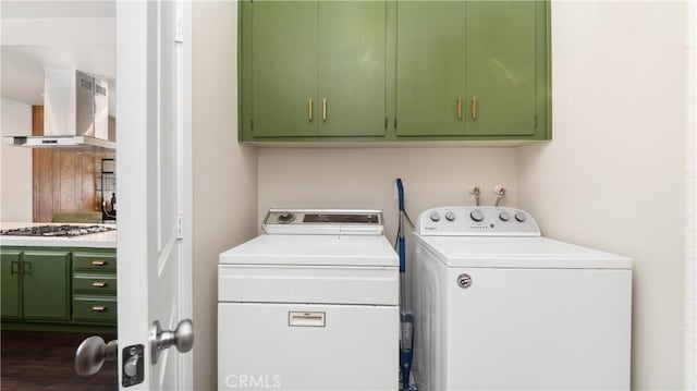 laundry area featuring washer and clothes dryer, dark wood finished floors, and cabinet space