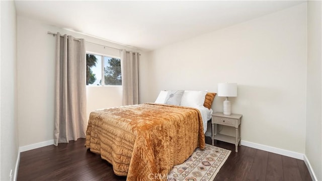 bedroom featuring dark wood finished floors and baseboards