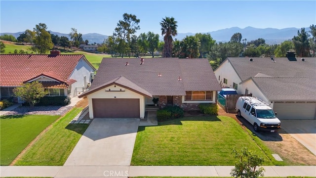 view of front facade featuring a garage, a front yard, concrete driveway, and a mountain view