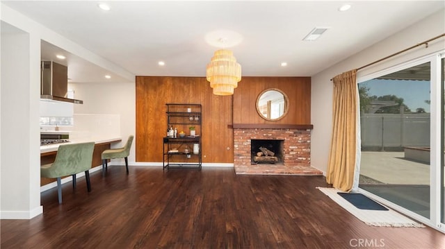 living area with wood walls, a fireplace, dark wood-style flooring, and recessed lighting