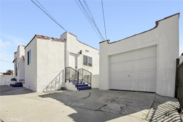 view of front facade featuring a garage, concrete driveway, and stucco siding