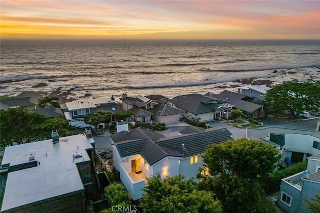 aerial view at dusk with a water view and a residential view