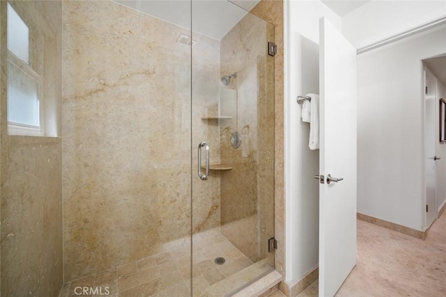 full bath featuring a stall shower and baseboards