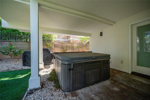 view of patio featuring fence and a hot tub