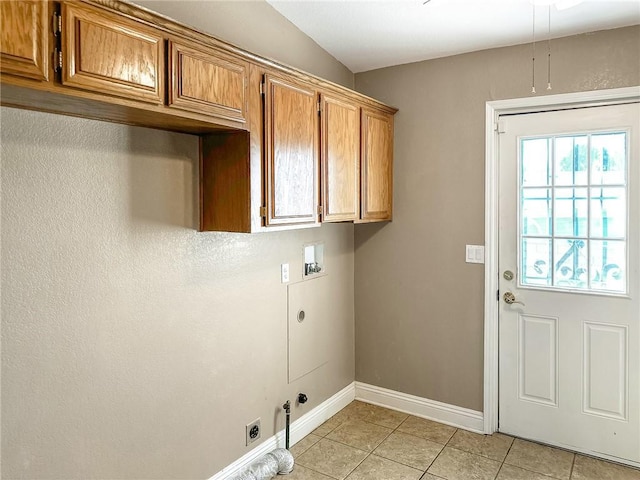 clothes washing area with cabinet space, light tile patterned floors, hookup for a gas dryer, hookup for an electric dryer, and washer hookup