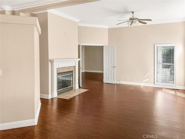 unfurnished living room featuring dark wood-type flooring, a ceiling fan, baseboards, ornamental molding, and a tiled fireplace