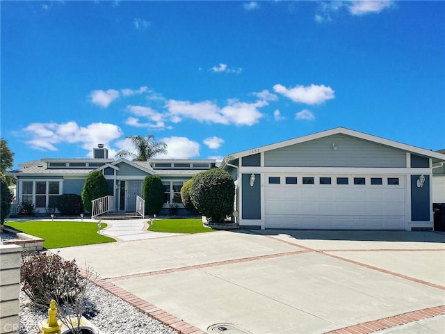 view of front of property with a garage, a front lawn, and concrete driveway