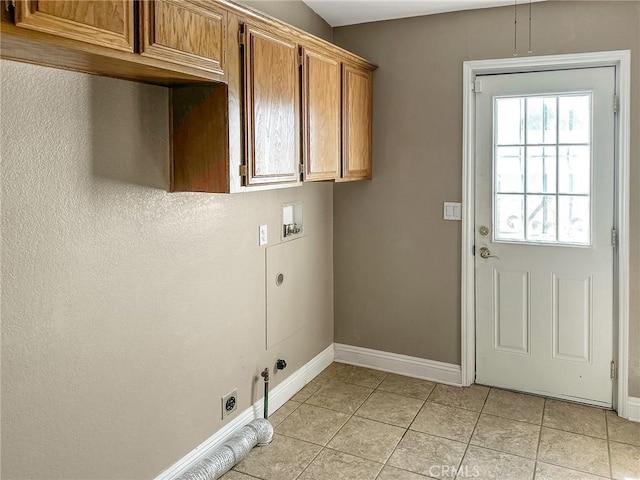 clothes washing area featuring cabinet space, light tile patterned floors, gas dryer hookup, washer hookup, and electric dryer hookup