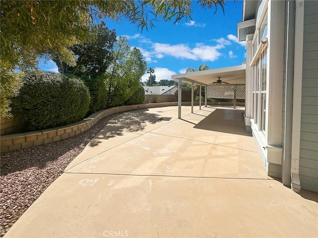 view of patio with ceiling fan and fence