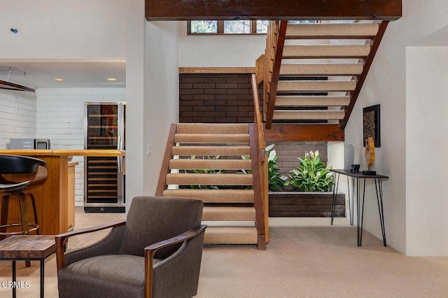 stairway with wet bar, beverage cooler, and carpet