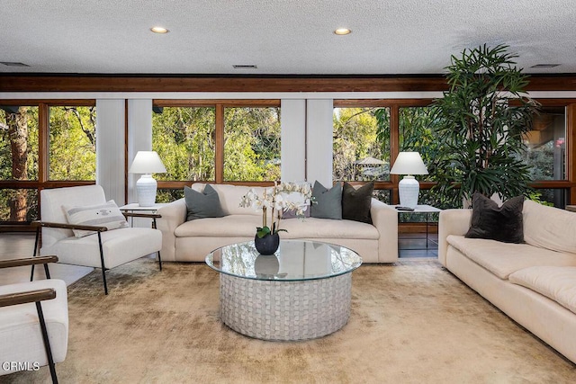 living room with light carpet, visible vents, and a textured ceiling