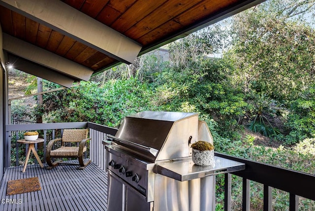 wooden deck featuring an outdoor kitchen and a grill