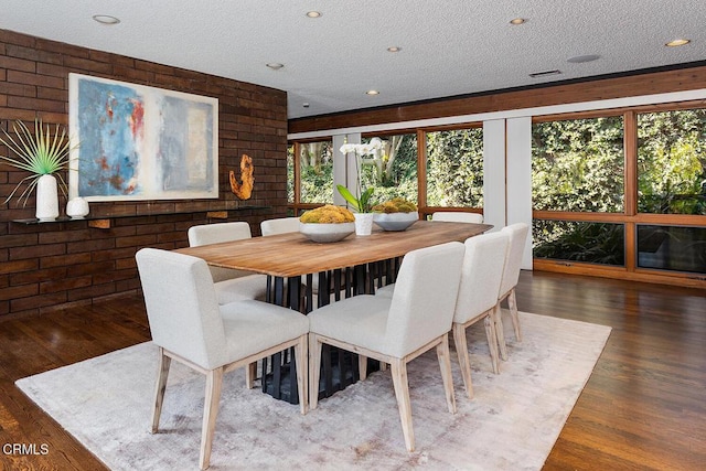 dining space with dark wood-style floors, a textured ceiling, and recessed lighting