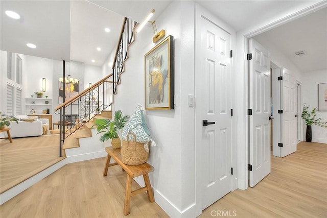 hallway featuring recessed lighting, baseboards, stairway, and light wood finished floors