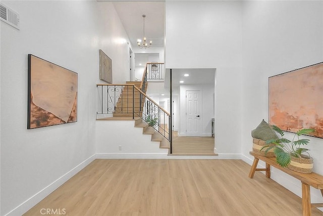 interior space featuring stairs, baseboards, visible vents, and light wood-style floors