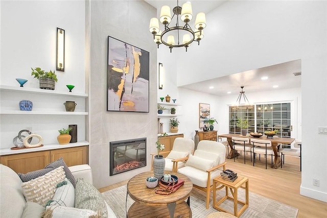 interior space featuring light wood-style floors, a fireplace, a chandelier, and recessed lighting