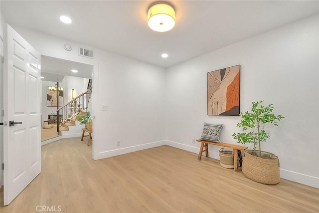 interior space featuring baseboards, stairs, visible vents, and wood finished floors