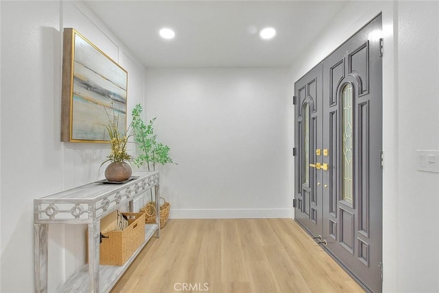 foyer entrance with recessed lighting, light wood-type flooring, and baseboards