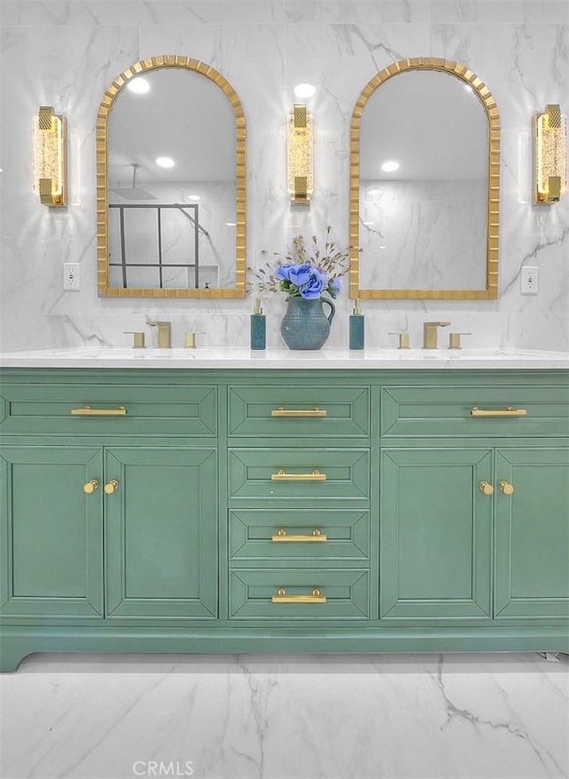 full bathroom with double vanity, marble finish floor, and a sink