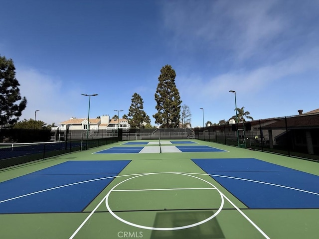 view of basketball court with community basketball court and fence