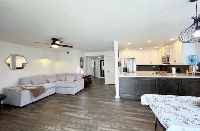 living room with recessed lighting, visible vents, dark wood-type flooring, ceiling fan, and a textured ceiling